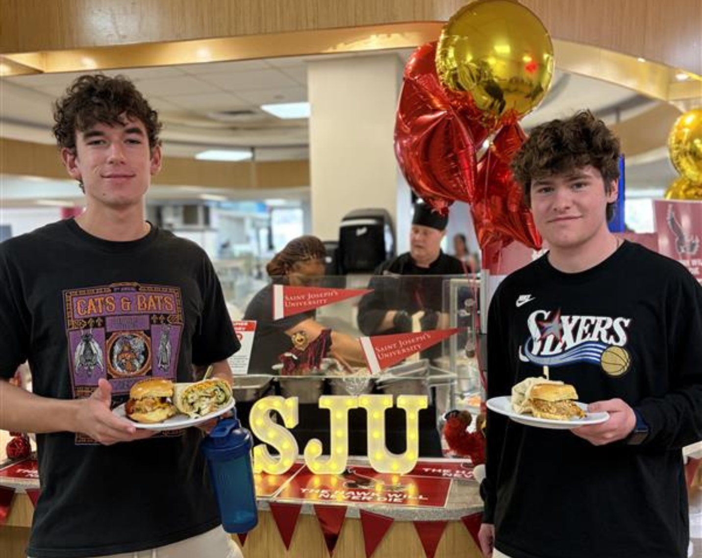 Two students hold up the Henwich and Hawk Wrap. 
